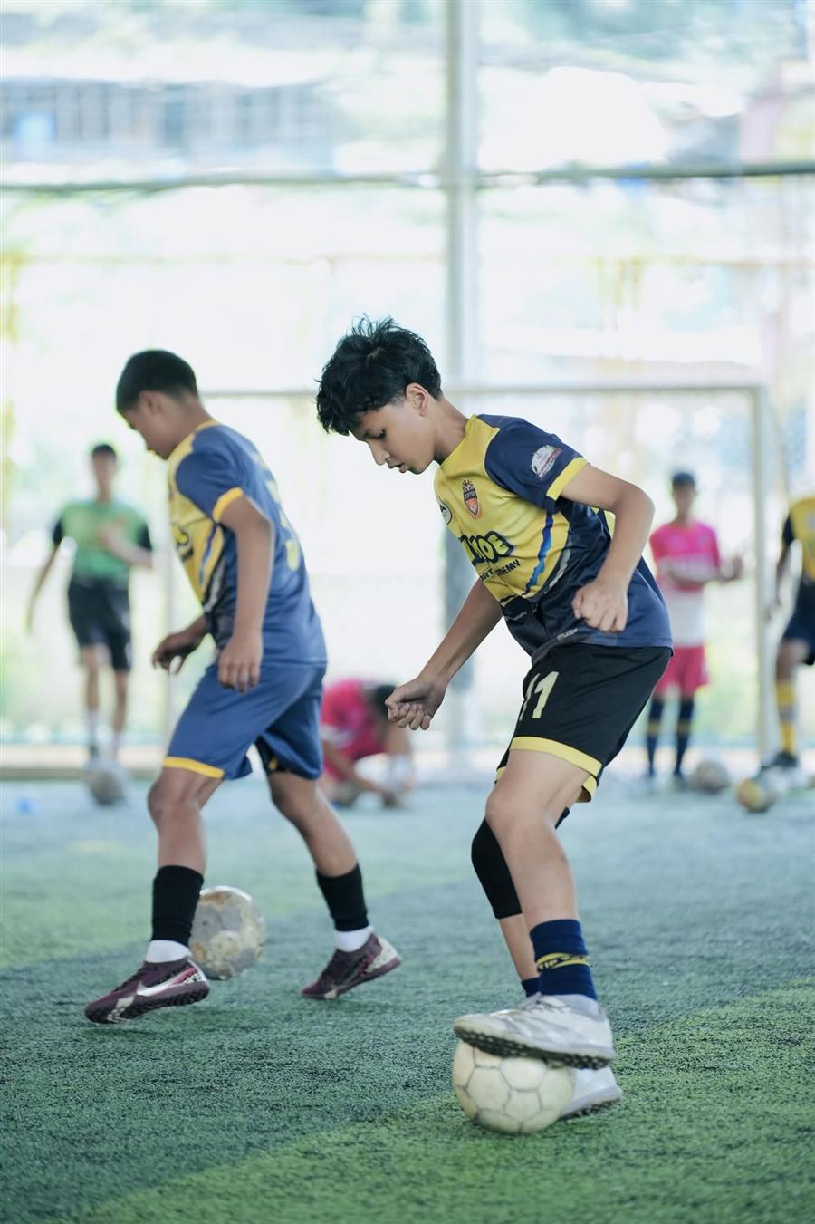 Young footballer in Tiptoe Academy yellow jersey training at Kathmandu football academy Nepal
